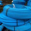 Large rolls / coils of blue MDPE water pipe.